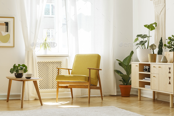 Real photo of a retro armchair coffee table and cabinet in a li